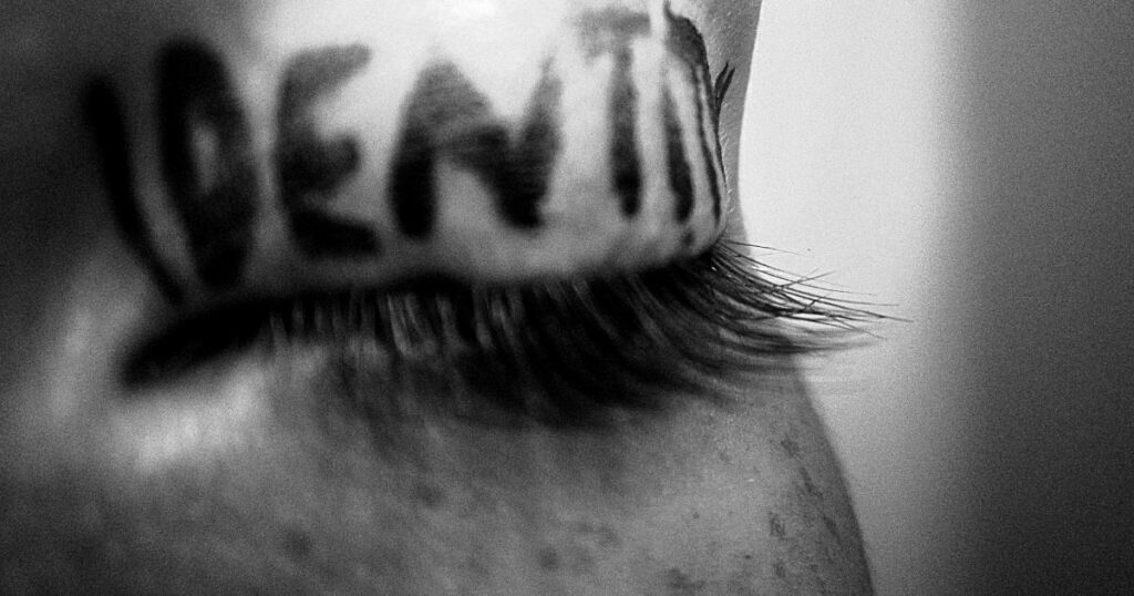 A closeup of an eyelid that says 'IDENTITY' in black