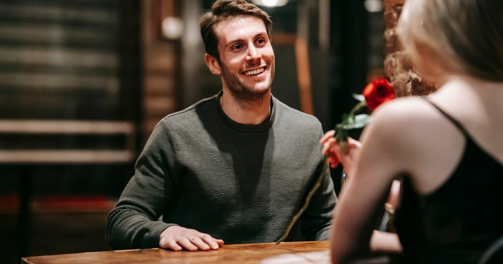 A man smiling while talking to a woman