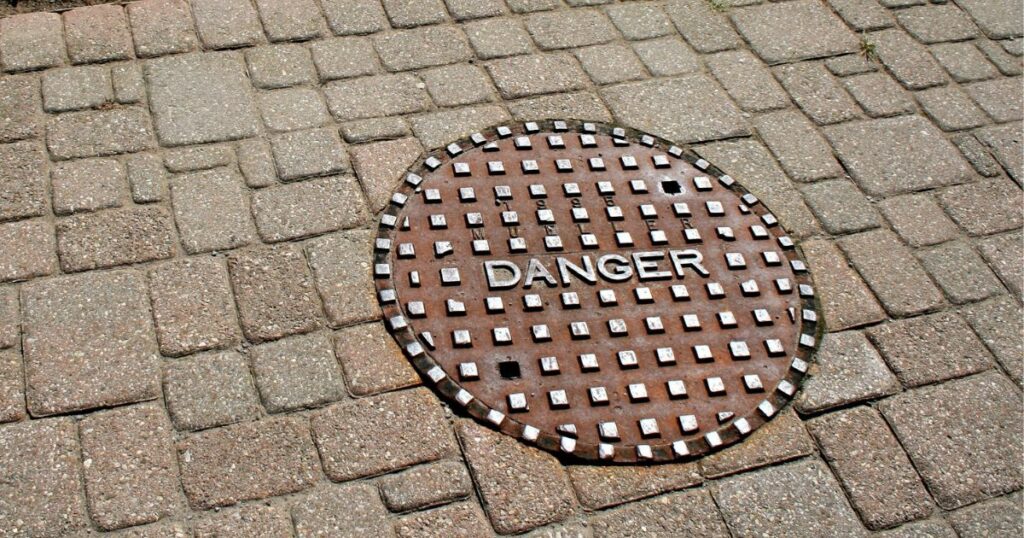 A manhole cover that reads 'DANGER'