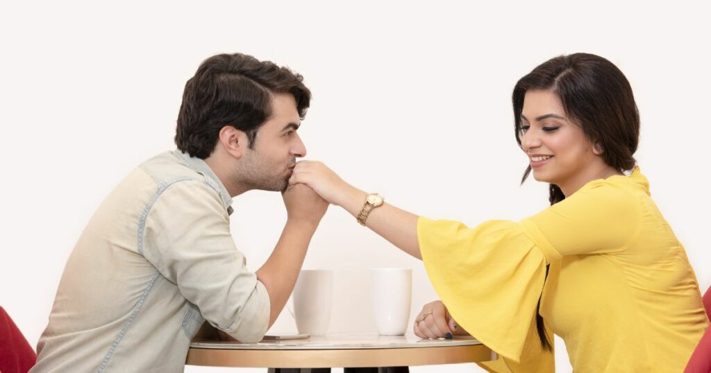 A guy kissing the hand of a woman