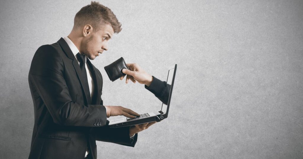 A hand with a wallet coming out of a computer