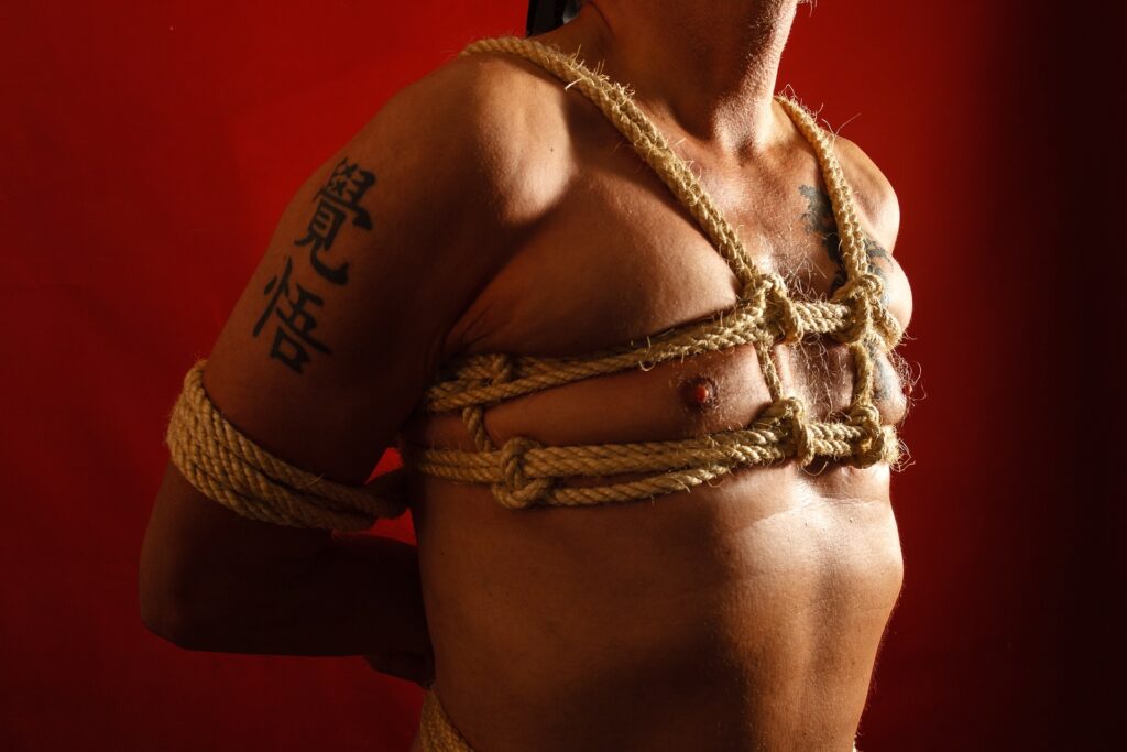 A closeup of a man tied up with rope